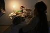 　停電中に自宅でろうそくに火をともす家族＝２０２５年１２月、ウクライナの首都キーウ（共同）