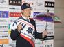 球団グッズなどを身につけ写真撮影に応じる下川隼佑＝エコスタ