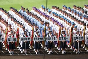 整列する新潟産大付の選手たちと、対戦校・花咲徳栄の選手たち=8月7日、阪神甲子園球場