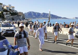 フランス南部マルセイユで始まった聖火リレーでトーチを掲げる走者=5月9日(共同)