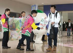トキエア就航初日、札幌・丘珠空港から新潟空港に到着した乗客を出迎える観光関係者=1月31日、新潟空港
