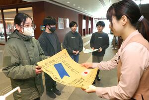 拉致問題の解決を呼びかけるポスターを手渡す北鯖石小学校の児童=柏崎市日石町4