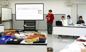 回収した古着を並べ、活用策を提案する新潟大学の「Kホーム」メンバー=加茂市役所