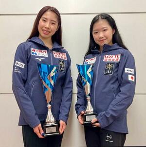 　フィギュアスケートのロンバルディア杯で獲得したトロフィーを持ち、ポーズをとる優勝した住吉りをん（左）と２位に入った中井亜美＝１５日、羽田空港