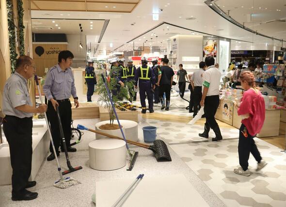 大雨の影響で新潟駅構内に入った水を掃除する従業員ら=10日、新潟市中央区