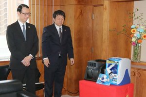 寄贈する電動ミストファンを紹介するグリーンライフの外山裕一社長(左)=三条市役所