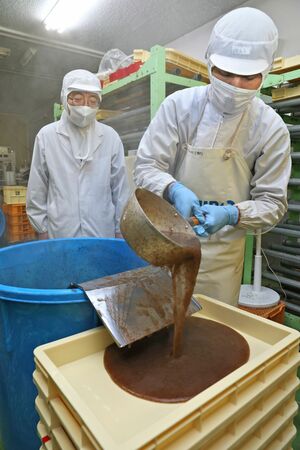 えごねりの製造の様子を見守る猪貝克浩さん(左)。原料には能登産のエゴノリも長く使ってきた=1月31日、長岡市新産2の猪貝