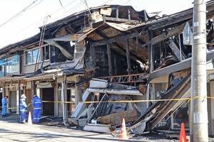 6棟を全焼した火災の現場。10月21日も警察と消防の実況見分が続いた=上越市本町2