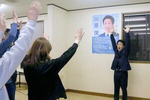 万歳をして喜びをあらわにする川原茂さん=4月14日、佐渡市上川茂