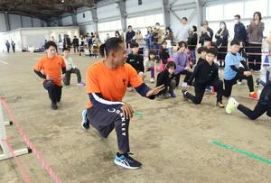 子どもたちに指導する陸上短距離の本郷タジュ選手＝４日、新潟市中央区