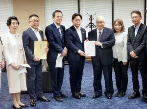 高額療養費制度に関する超党派の国会議員連盟から、要請を受ける福岡厚労相(左から4人目)=25日午後、厚労省