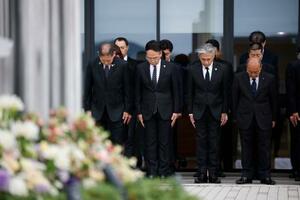 　熊本地震の「前震」から１０年となり、震災記念公園で黙とうする熊本県益城町の西村博則町長（左端）ら＝１４日午前、益城町