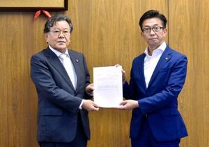 三重県桑名市役所で、答申書を伊藤徳宇市長(右)に手渡す森川仁委員長=30日午前