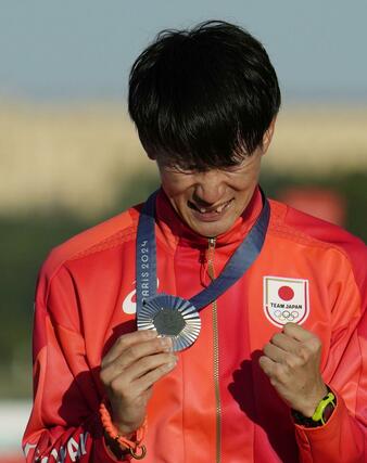 近代五種男子で獲得した銀メダルを手に、表彰式で感極まる佐藤大宗＝パリ郊外（共同）