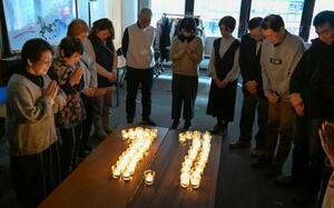 　能登半島地震の発生時刻に合わせ黙とうする石川県からの広域避難者ら＝２４日午後４時１０分、大阪市中央区