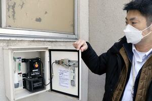 地震を検知して開く鍵入りのボックス。電力は不要だが、地震が設定値に届かないと開かない=村上市の村上小学校