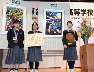 最高賞の文部科学大臣賞に輝いた佐渡中等教育学校のメンバーと受賞作=3月20日、佐渡市相川栄町