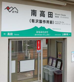 「有沢製作所前」の愛称が付けられた「えちごトキめき鉄道」南高田駅の看板=4月8日、上越市南高田町