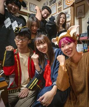 「まこHOUSE」の「ご飯会」で、仮装姿の参加者たちとポーズを決める山本昌子(右端)。近況報告をしながら食事を楽しみ、ゲームで盛り上がることも=2025年10月、東京都杉並区