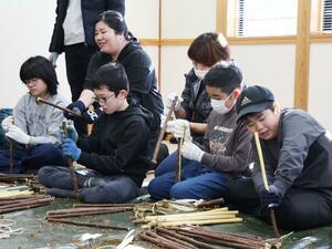 和紙の原料になるコウゾの皮むきを体験する参加者ら＝柏崎市加納