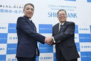 　資本業務提携を発表し、握手する池田泉州ＨＤの阪口広一社長（左）と滋賀銀行の久保田真也頭取＝１７日午後、大阪市