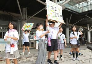 黒埼茶豆を配布する黒埼南小3年の児童=JR新潟駅南口広場