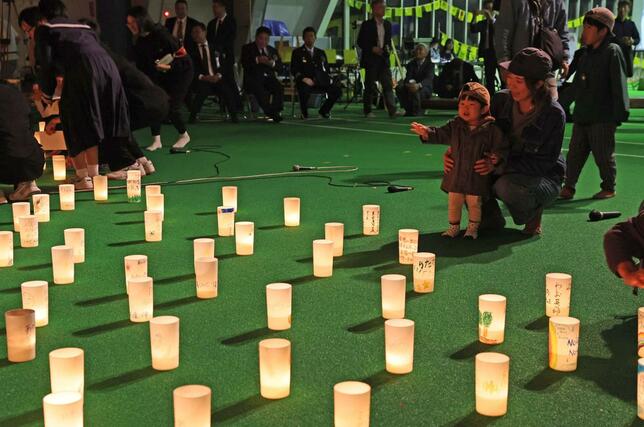 川口の１０・２３追悼式典でキャンドルが点灯され、優しい光に見入る人ら＝長岡市川口中山の川口運動公園すぱーく川口
