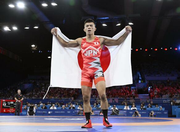 男子グレコローマン６０キロ級で金メダルを獲得し、日の丸を掲げる文田健一郎＝パリ（共同）