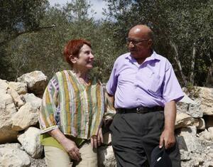 自宅前で、サリムさん（左）と談笑するアンさん＝９月