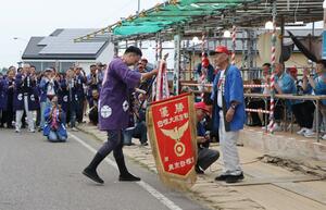 白根大凧合戦の閉戦式で優勝旗を受け取る役者組=9日、新潟市南区の中ノ口川堤防