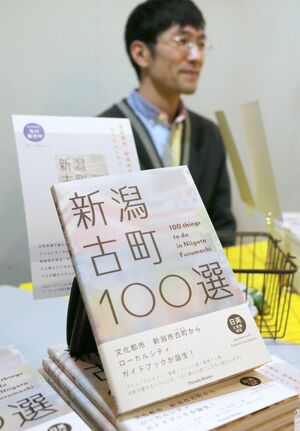 古町エリアのお薦めスポットをまとめた書籍「新潟古町100選」。複合施設「SAN」で近藤潤さんらが販売した=新潟市中央区古町通3