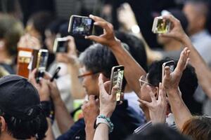 参院選の候補者らの街頭演説をスマートフォンで撮影する人たち=19日、札幌市