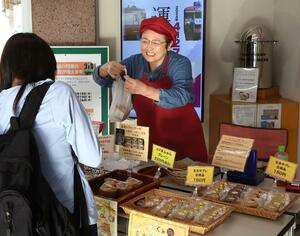 玄米クッキーや揚げパン、シフォンケーキを販売する柴田久美子さん=妙高市の新井駅