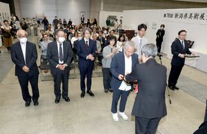 県展入賞者に盾や賞状が贈られ、会場は拍手に包まれた=6月1日、新潟市中央区の朱鷺メッセ