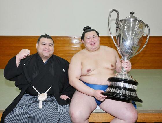 大相撲夏場所で優勝し、賜杯を手に笑顔の大の里。左は優勝パレードで旗手を務めた高安＝２５日、両国国技館（代表撮影）