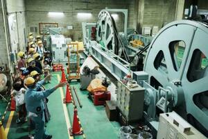 南海電鉄高野山駅で行われた「駅長おしごと体験」で、ケーブルカーの巻き上げ機を見学する子どもたち=23日午後
