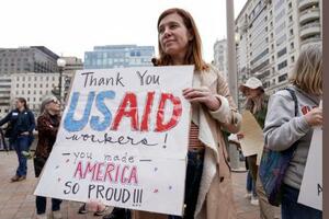 USAIDに感謝を表すボードを持つ人=2月、ワシントン(AP=共同)