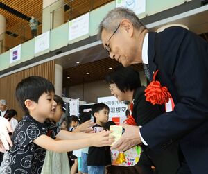 赤い羽根共同募金運動の開始セレモニーで募金を手渡す園児=10月1日、新潟市中央区