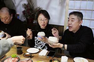 北京市内の焼き肉店でおわんに山盛りの新潟県産コシヒカリを食べる中国人客ら=12月16日(共同)