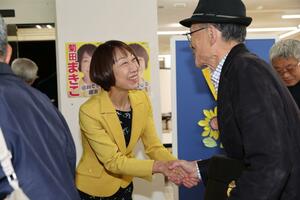 当選確実となり、支持者と握手する菊田真紀子さん=10月27日21時15分、三条市荒町2