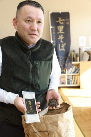 谷人倶楽部が販売する「七里そば」の乾麺を手にする加藤幸夫さん＝関川村安角