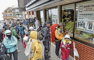 山開きを迎えた富士山の山梨県側で窓口に列を作る登山者たち＝７月１日午前