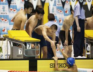男子400メートルメドレーリレー決勝 優勝した長岡大手。アンカーの泳ぎ切った本間匠騎に駆け寄るメンバー=ダイエープロビスフェニックスプール
