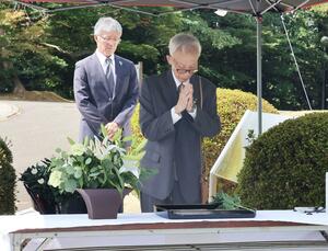 満州柏崎村の塔の前で献花し、平和を祈る巻口弘さん(右)=柏崎市緑町