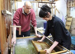 紙すきのアドバイスをするポールさん（左）＝長岡市小国町小栗山