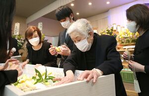 棺に収められた金巻保男さんの亡きがらに触れ、別れを惜しむ遺族=新潟市中央区