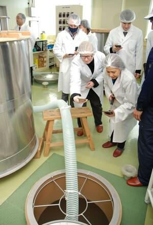 酒造りの工程を興味深そうに見学したALTの参加者=3月16日、阿賀町津川