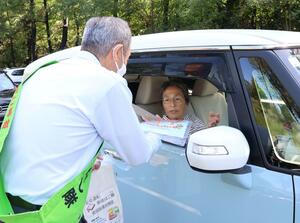 ドライバーにそうめんを手渡し、安全運転を呼びかけた街頭指導=新潟市中央区関屋