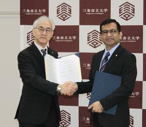 連携協定に調印する原口央校長（左）とアハメド・シャハリアル理事長＝三条市上須頃