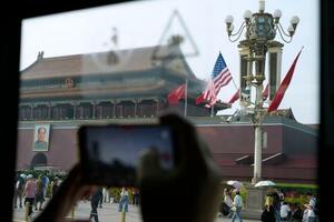 米中両国の国旗が掲げられた北京の天安門前=13日(共同)